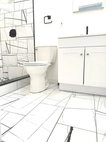 a white toilet sitting next to a shower