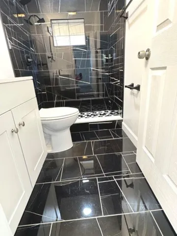 a bathroom with a toilet and a shower