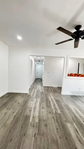 a view of empty room with wooden floor