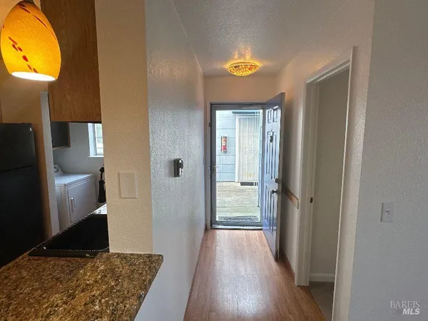 a view of a hallway with wooden floor and a living room