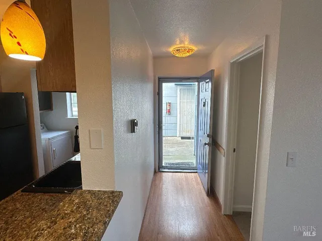a view of a hallway with wooden floor and a living room