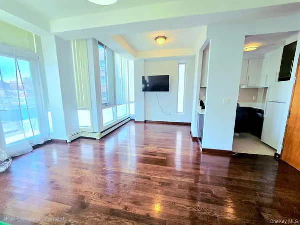 a view of a big room with wooden floor and windows