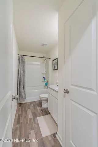 a bathroom with a granite countertop sink a toilet and shower