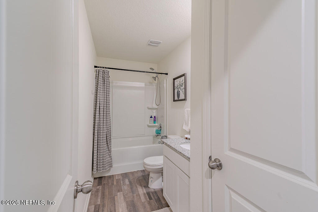 45148 Red Brick Drive Callahan, FL 32011 - Photo 19 of 32 a bathroom with a granite countertop sink a toilet and shower