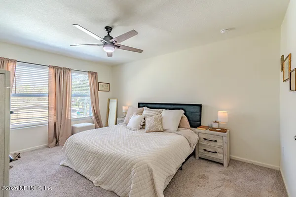 a bedroom with a bed and a large window