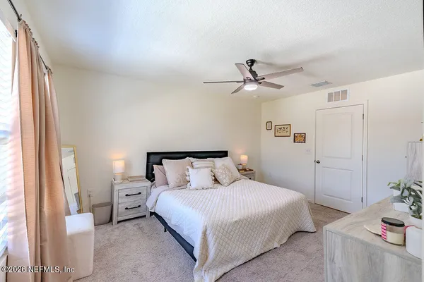 a bedroom with a bed chandelier and a window
