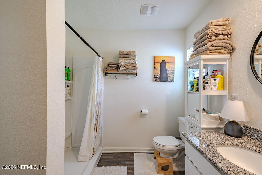 45148 Red Brick Drive Callahan, FL 32011 - Photo 26 of 32 a bathroom with a granite countertop sink a toilet and a shower