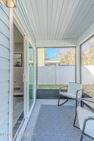 a balcony with wooden floor and furniture