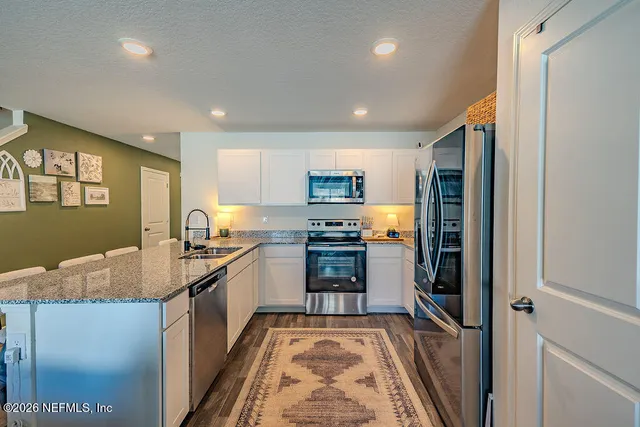 a kitchen with granite countertop stainless steel appliances and counter space