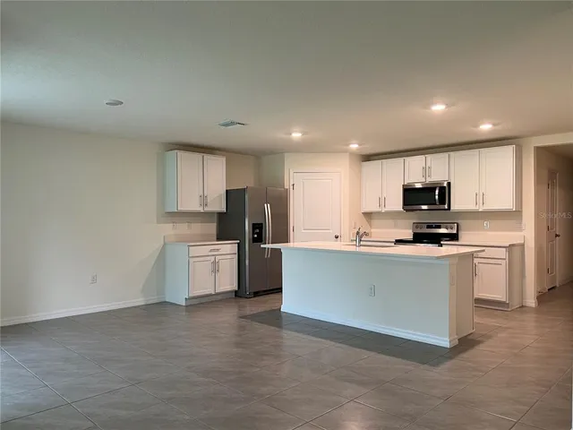 a kitchen with stainless steel appliances a refrigerator sink and microwave