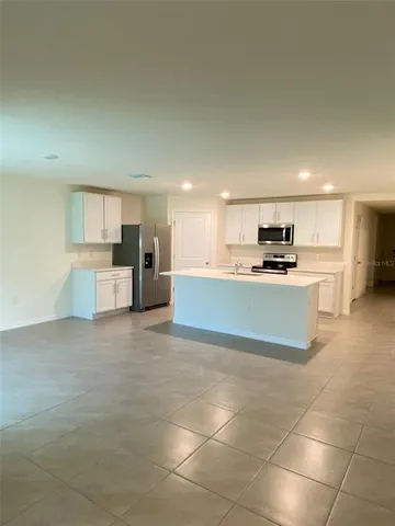 a large kitchen with a stove a refrigerator and a sink