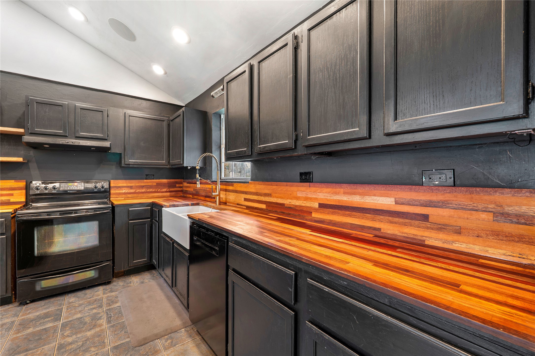 358 Easley Road Smithville, TX 78957 - Photo 10 of 36 Kitchen with crafted wooden countertops and sleek black cabinetry define this functional culinary space.