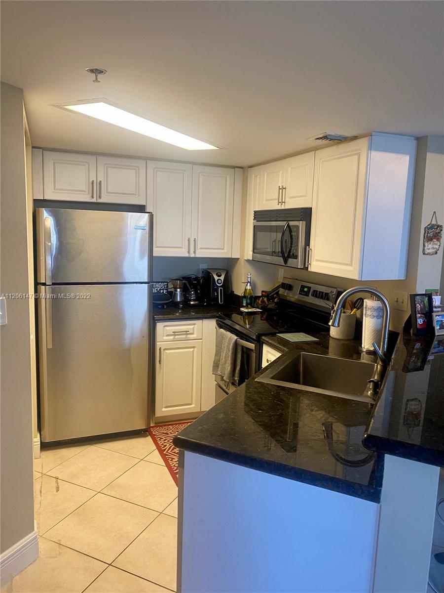 2351 Douglas Road, Unit 605 Miami, FL 33145 - Photo 5 of 10 a kitchen with stainless steel appliances granite countertop a refrigerator a stove a sink dishwasher and a refrigerator
