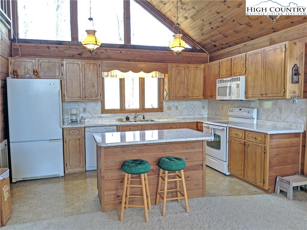 296 Grousemoor Road Deep Gap, NC 28618 - Photo 7 of 27 a kitchen with kitchen island granite countertop wooden cabinets a counter top space and stainless steel appliances