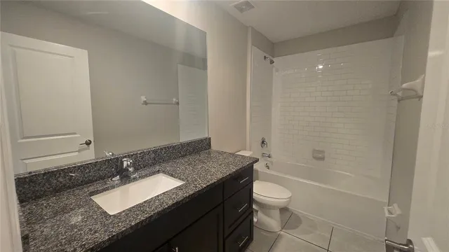 a bathroom with a bathtub shower sink vanity and a toilet