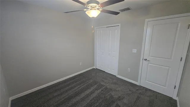 a view of empty room with ceiling fan
