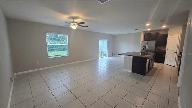 a view of a kitchen with kitchen island granite countertop a refrigerator oven a sink and dishwasher