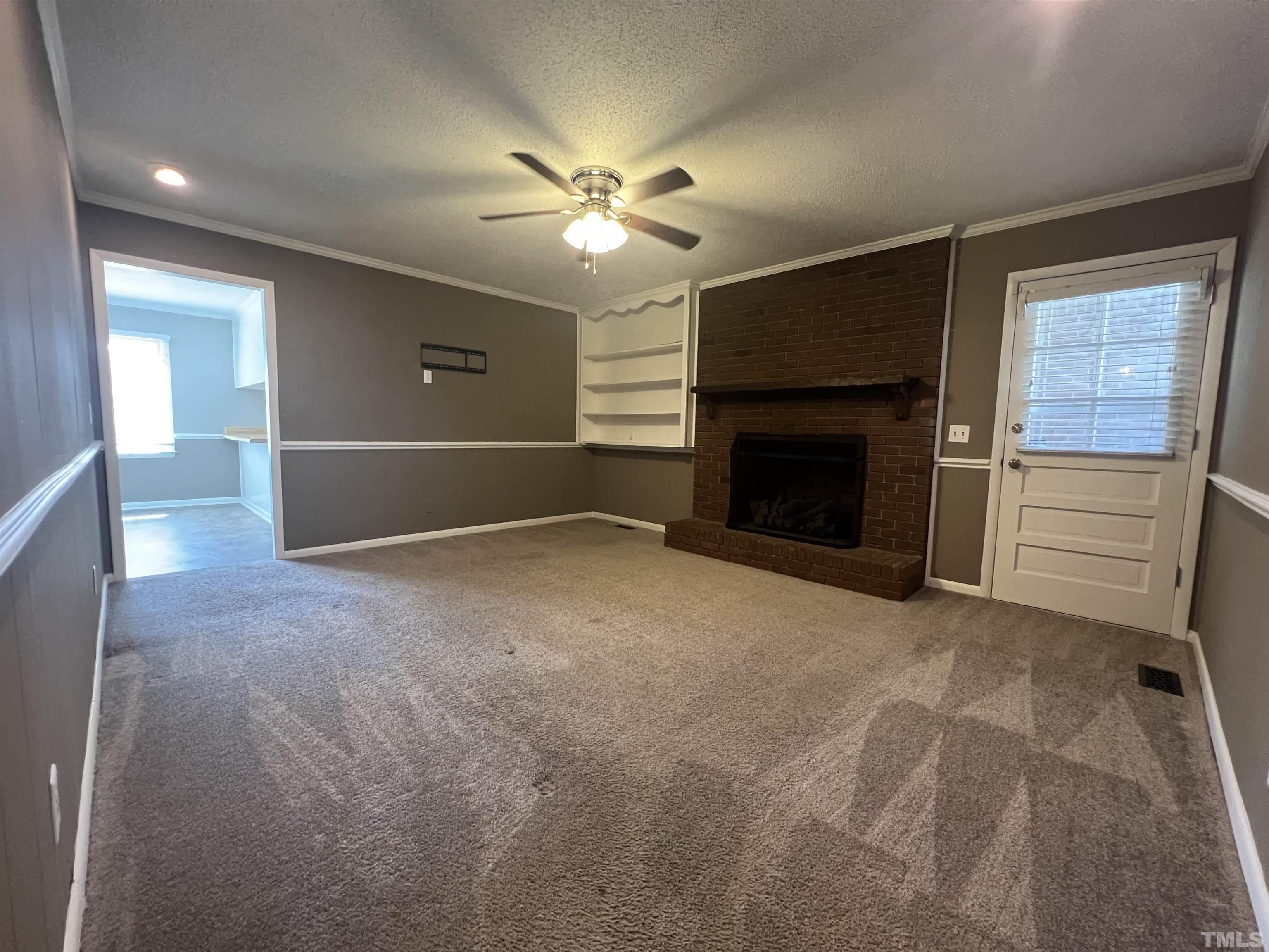 104 Marion Drive Erwin, NC 28339 - Photo 12 of 28 a view of empty room with fireplace and fan