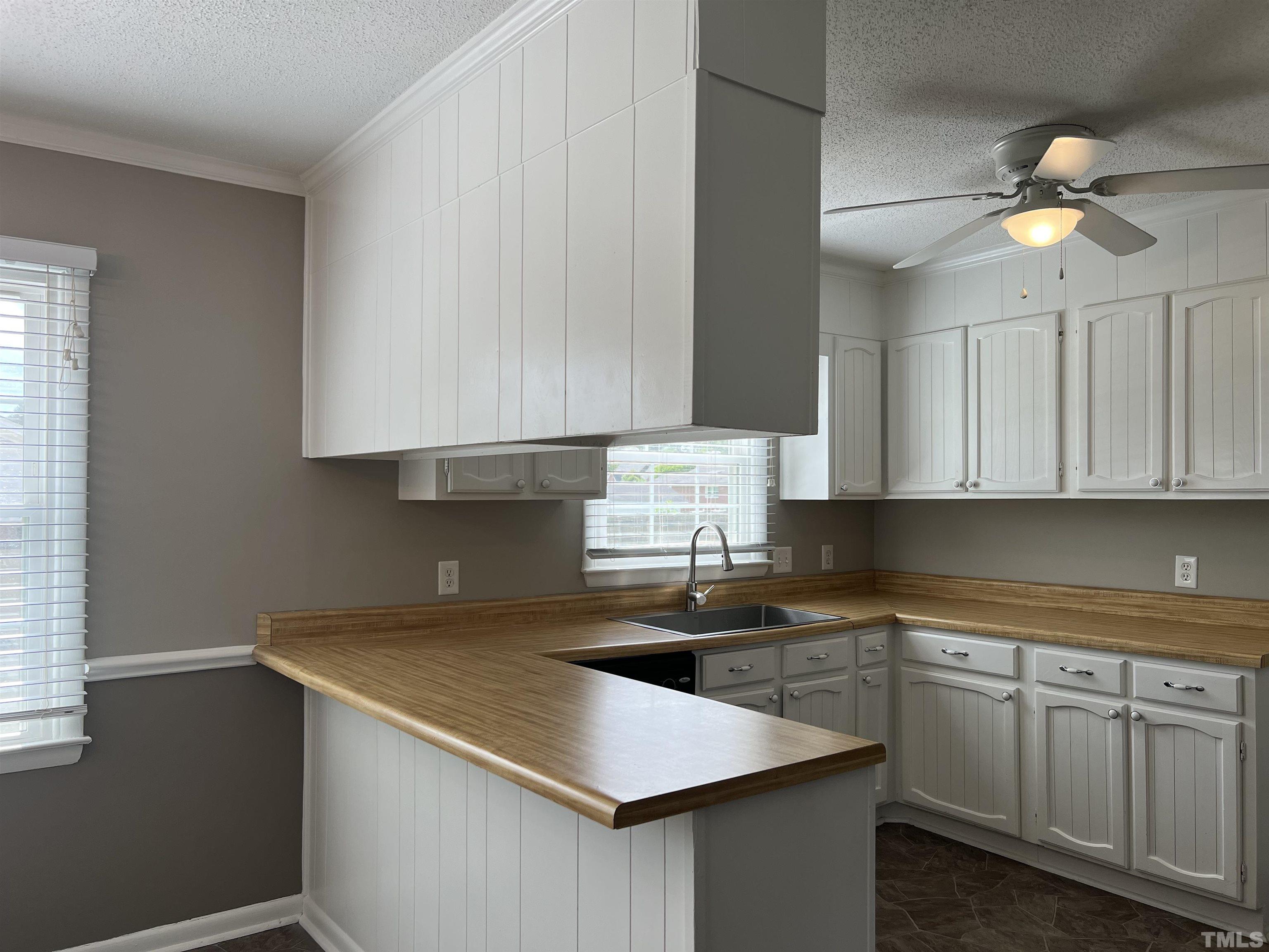 104 Marion Drive Erwin, NC 28339 - Photo 7 of 28 a kitchen with a sink dishwasher and white cabinets with wooden floor