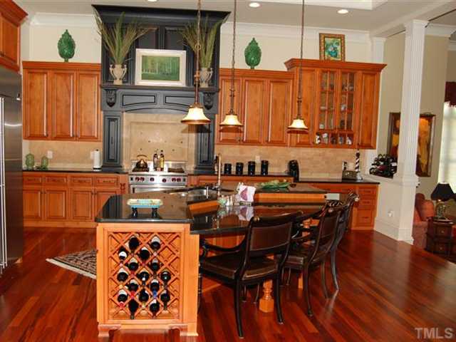 6024 Over Hadden Court Raleigh, NC 27614 - Photo 2 of 12 a kitchen with stainless steel appliances a sink a stove a dining table and chairs with wooden floor