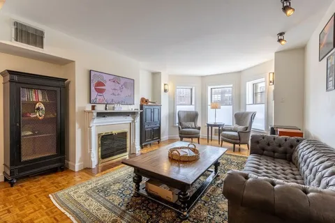 a living room with furniture a rug and a fireplace