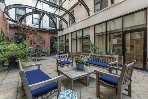 a view of a patio with couches table and chairs and potted plants