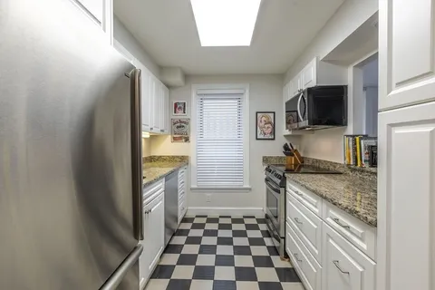 a kitchen with a refrigerator and a stove top oven