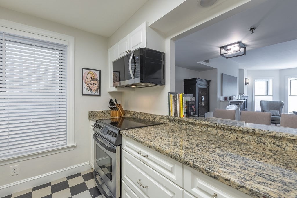 416 Commonwealth Avenue, Unit 212 Boston, MA 02215 - Photo 6 of 19 a view of a kitchen with kitchen island granite countertop a sink and a stove top oven