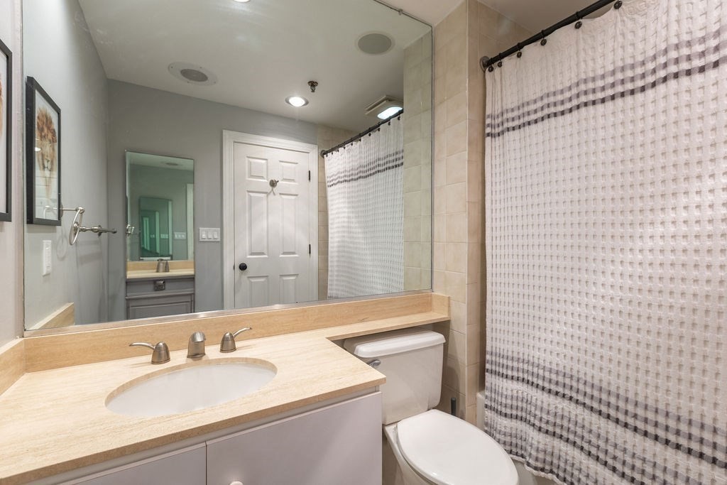 416 Commonwealth Avenue, Unit 212 Boston, MA 02215 - Photo 8 of 19 a bathroom with a sink a toilet a mirror and shower curtain