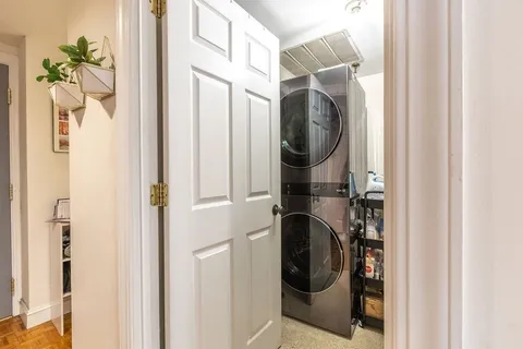 a utility room with wooden floor washer and dryer