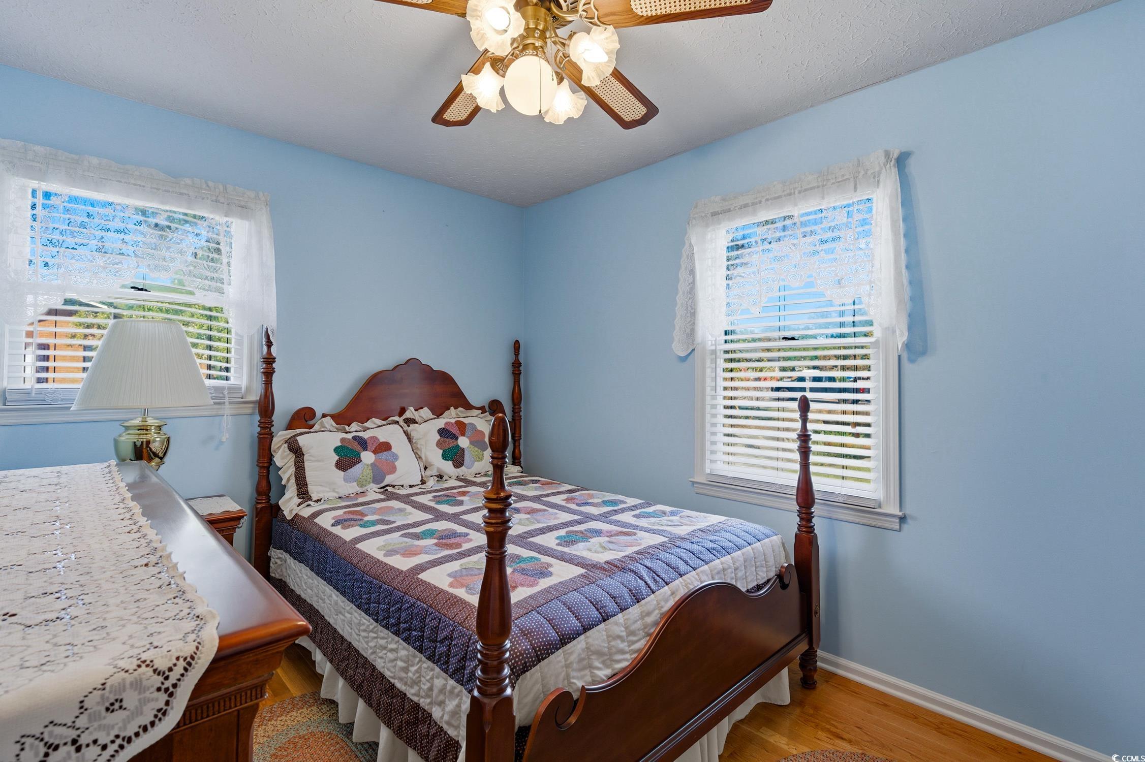 1605 Sessions Street Conway, SC 29526 - Photo 17 of 20 Bedroom featuring wood finished floors, multiple windows, a ceiling fan, and a textured ceiling