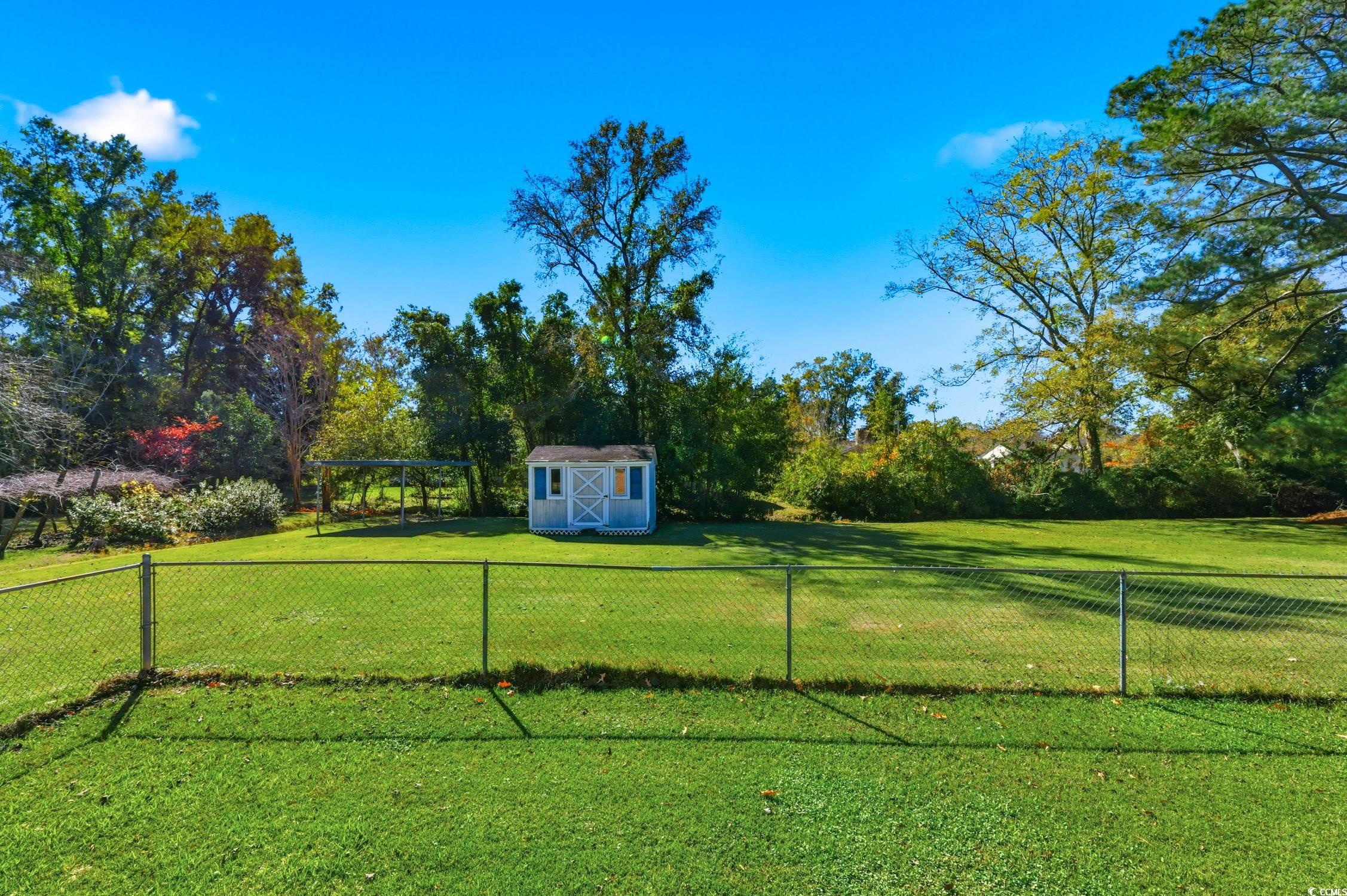 1605 Sessions Street Conway, SC 29526 - Photo 4 of 20 Fenced backyard with a storage shed and view of scattered trees