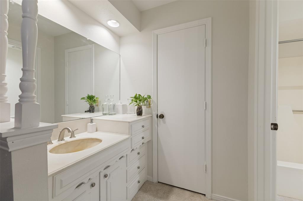 705 South Grove Road Richardson, TX 75081 - Photo 21 of 26 Bathroom vanity with an integrated oval sink, brushed nickel faucet, and white cabinetry featuring decorative hardware