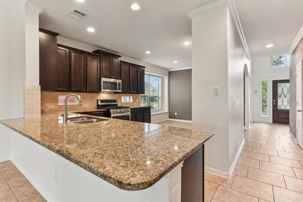 a kitchen with a sink a counter top space appliances and cabinets