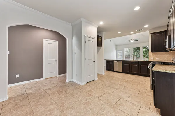 a view of kitchen and kitchen with granite countertop cabinets