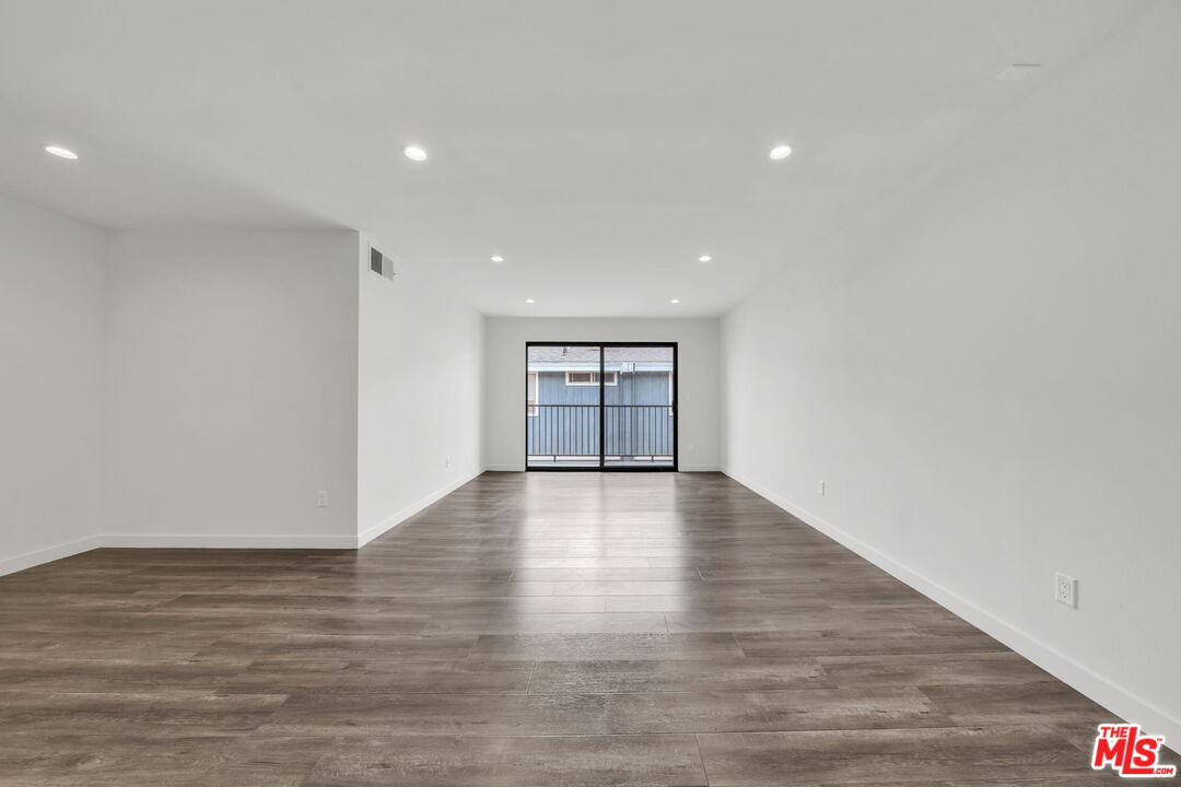 7453 Haskell Avenue, Unit 7 Van Nuys, CA 91406 - Photo 3 of 14 a view of an empty room with wooden floor and a window