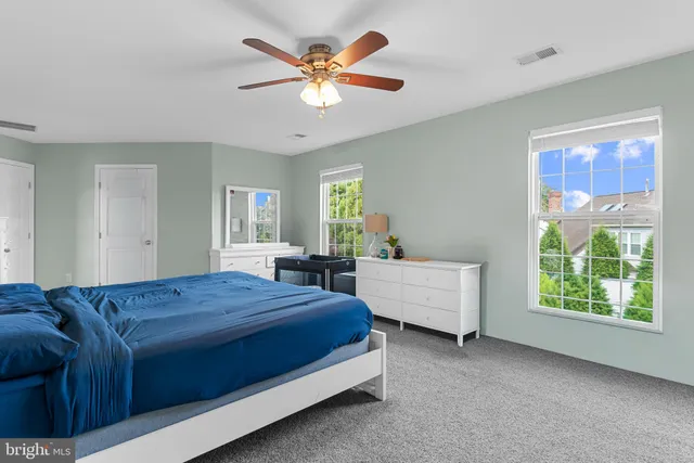 a spacious bedroom with a bed and a chandelier