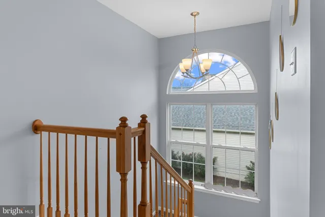 a view of a hallway with a large window and chandelier