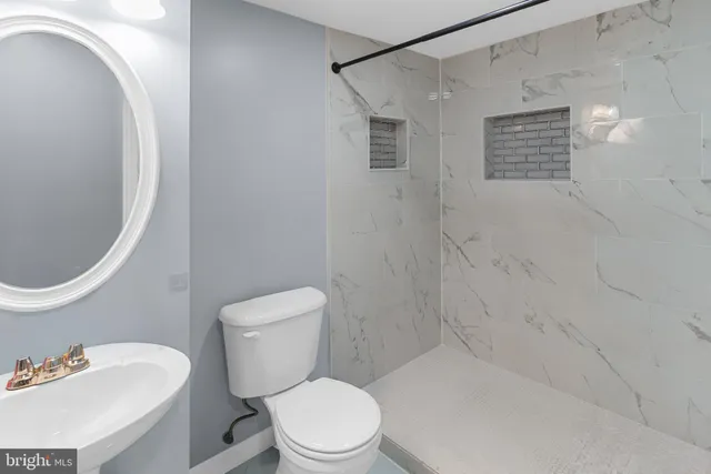 a white toilet sitting next to a bathroom sink