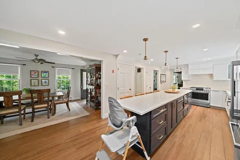a kitchen with a stove and wooden floor