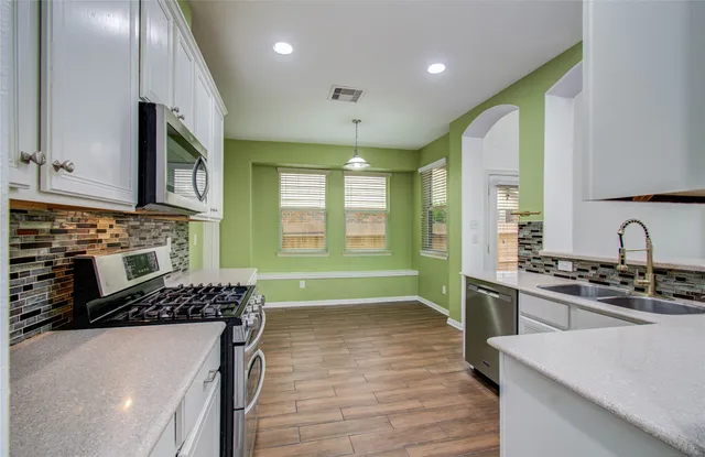 a kitchen with kitchen island granite countertop a stove and a sink