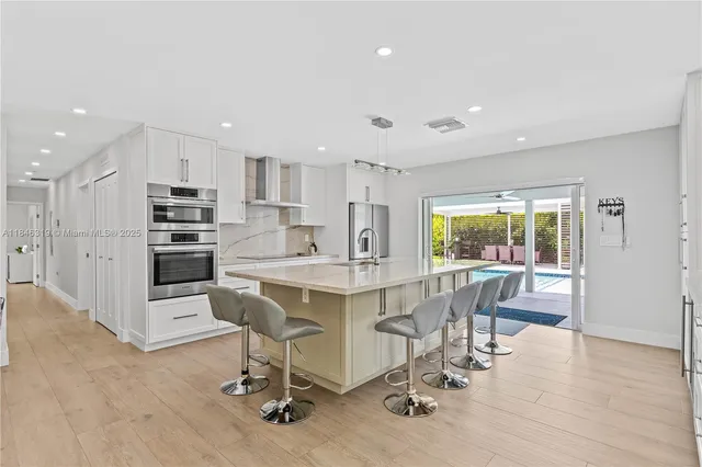 a kitchen with stainless steel appliances kitchen island granite countertop a table and chairs