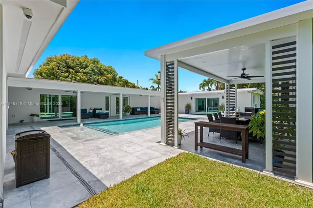 a view of a patio with couches and table and chairs under an umbrella