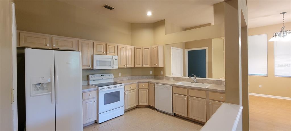 10050 Southwest 52nd Road Gainesville, FL 32608 - Photo 11 of 39 a kitchen with a sink a refrigerator and cabinets