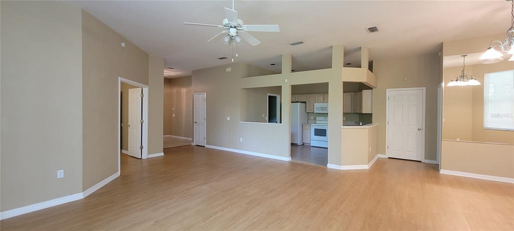 10050 Southwest 52nd Road Gainesville, FL 32608 - Photo 12 of 39 a view of a big room with wooden floor and a kitchen