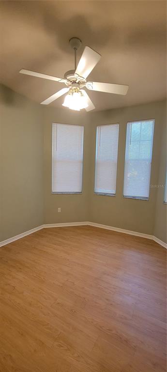 10050 Southwest 52nd Road Gainesville, FL 32608 - Photo 20 of 39 a view of an empty room with chandelier fan and wooden floor
