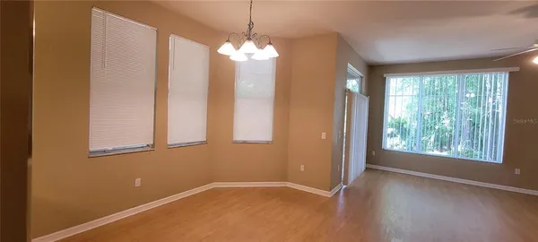 an empty room with windows and chandelier