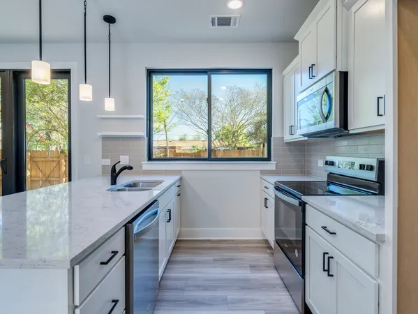 a kitchen with stainless steel appliances granite countertop a stove and a sink