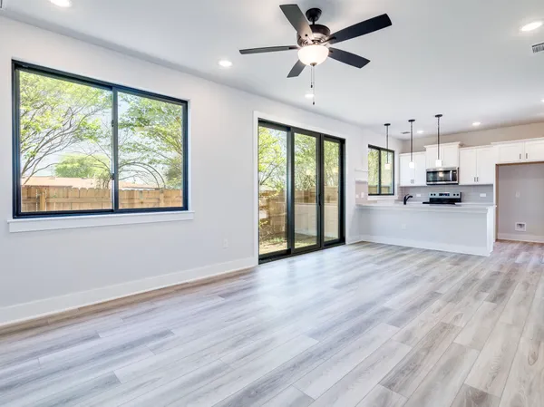 a view of a kitchen with wooden floor and a ceiling fan
