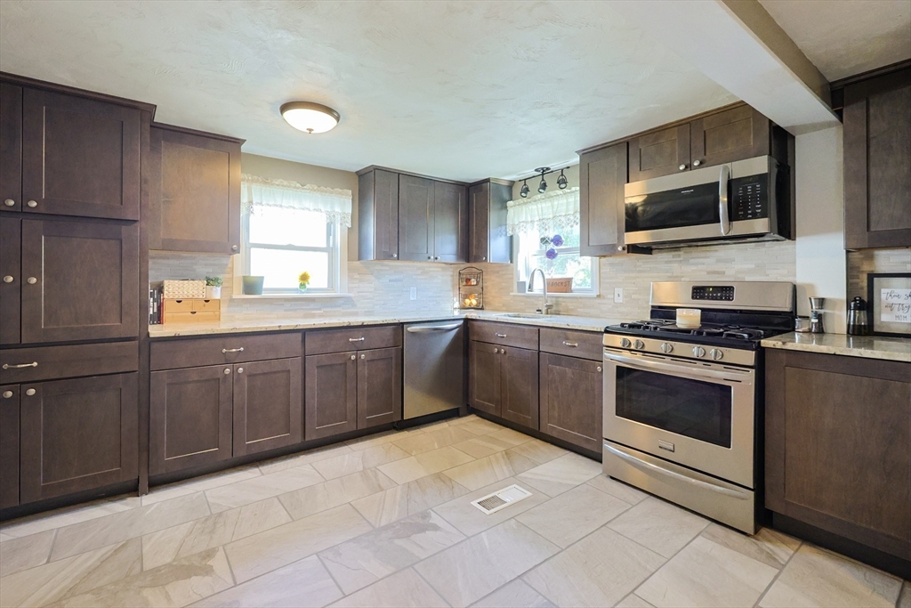 22 Rock Street Acushnet, MA 02743 - Photo 6 of 41 a kitchen with stainless steel appliances granite countertop a stove sink and microwave